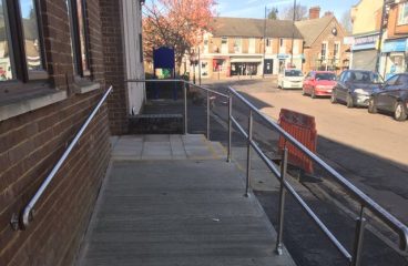 Hand rails on a ramp outside of a commercial building by Bridgewater Glass